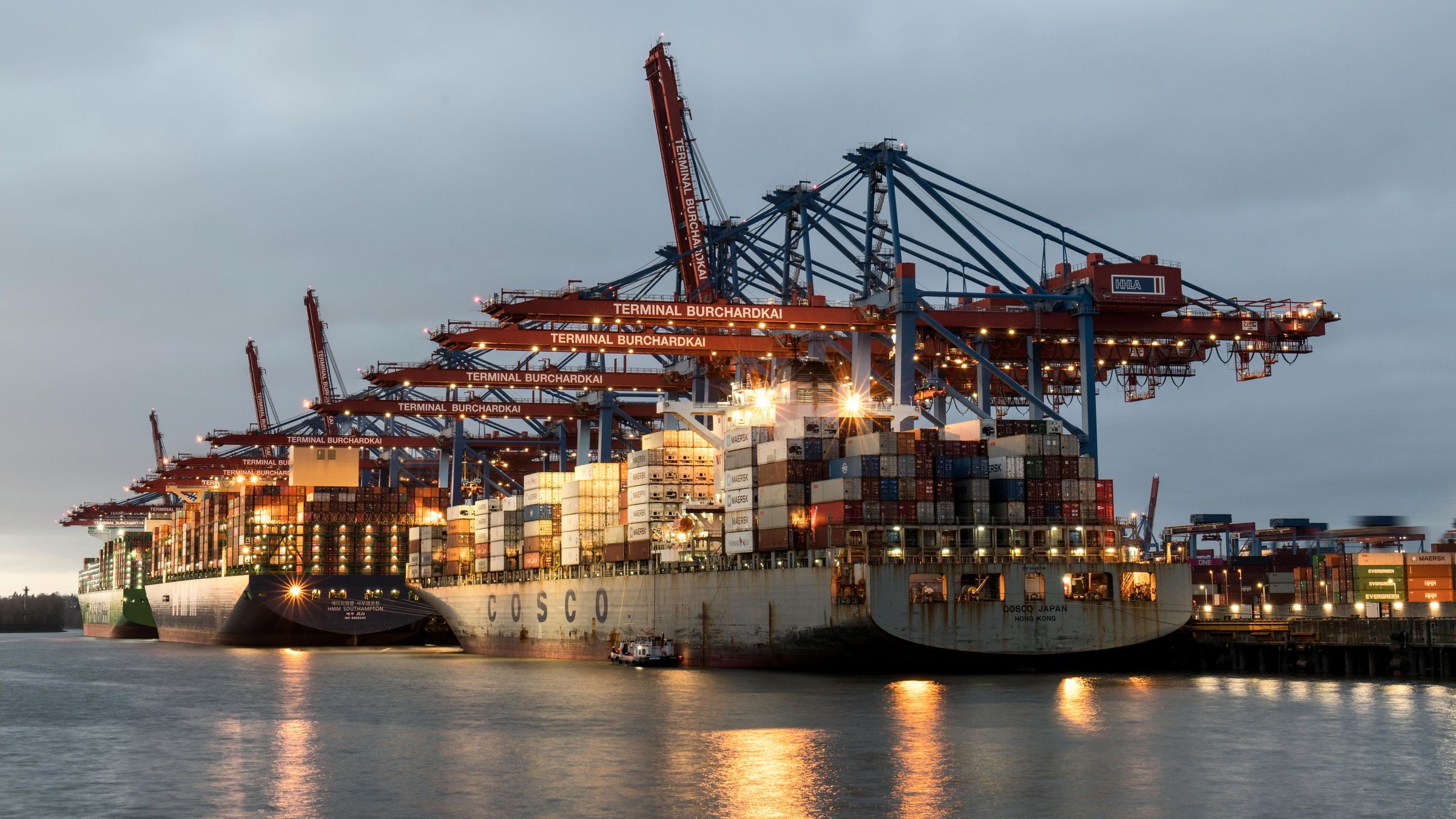 Containers stacked on a quay at a Dutch port at first light, with cranes over the berth