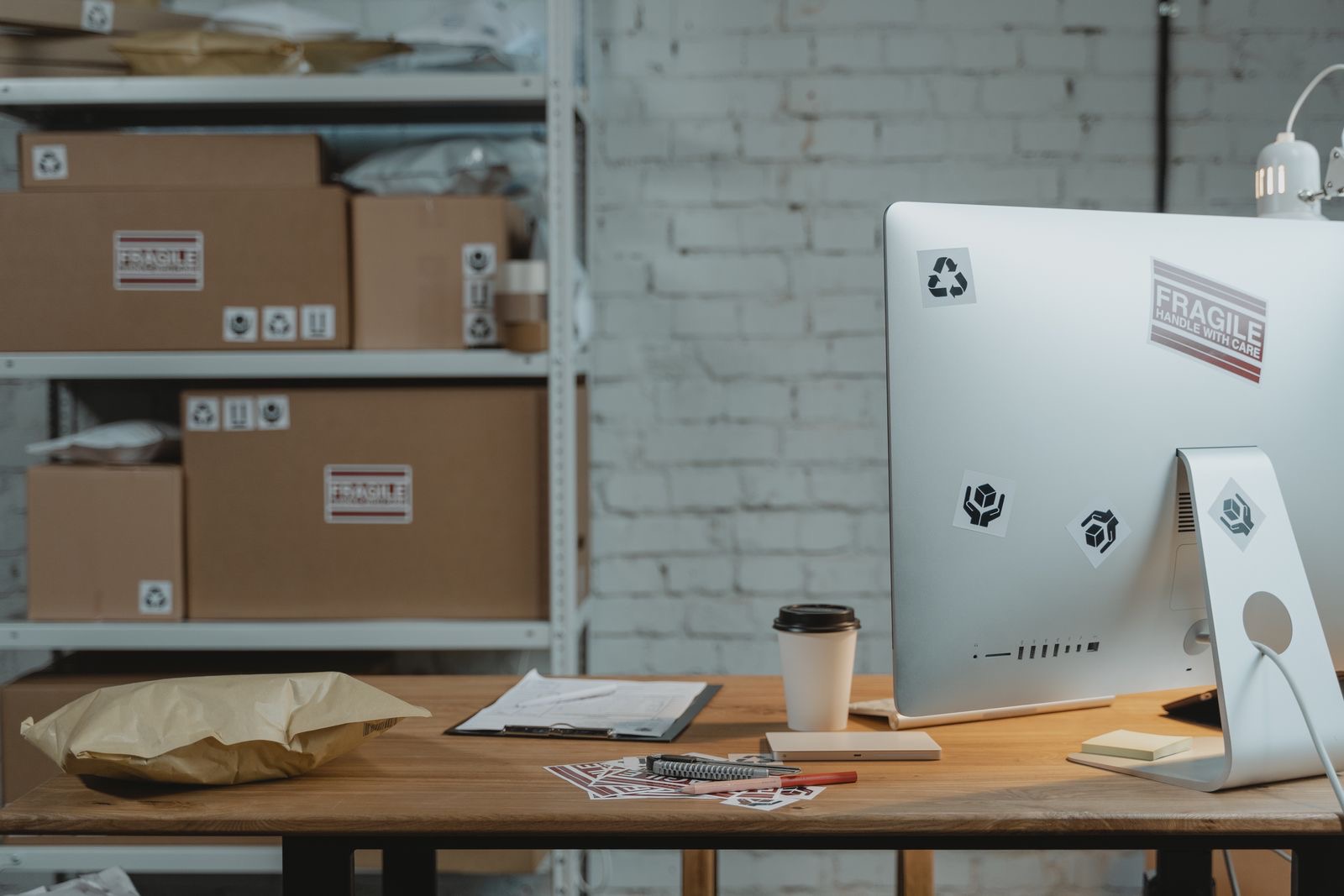 Shipping papers and a laptop on an office desk, with a folder ready for an import file