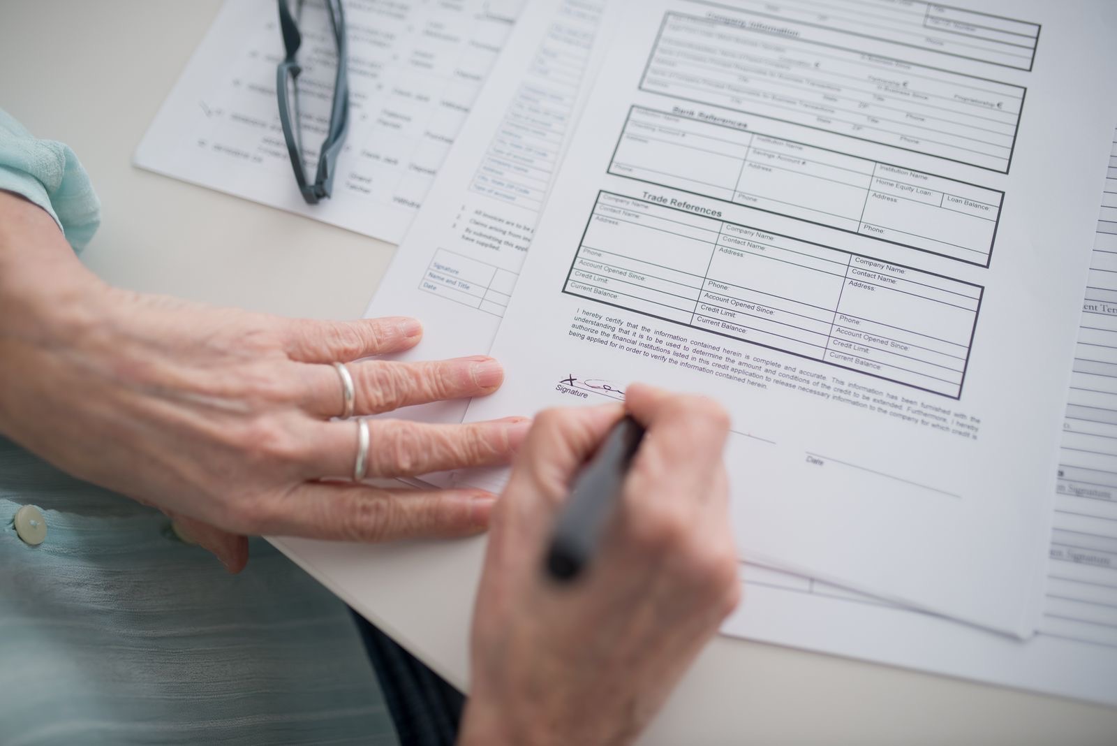 Documents being signed with a pen at a desk