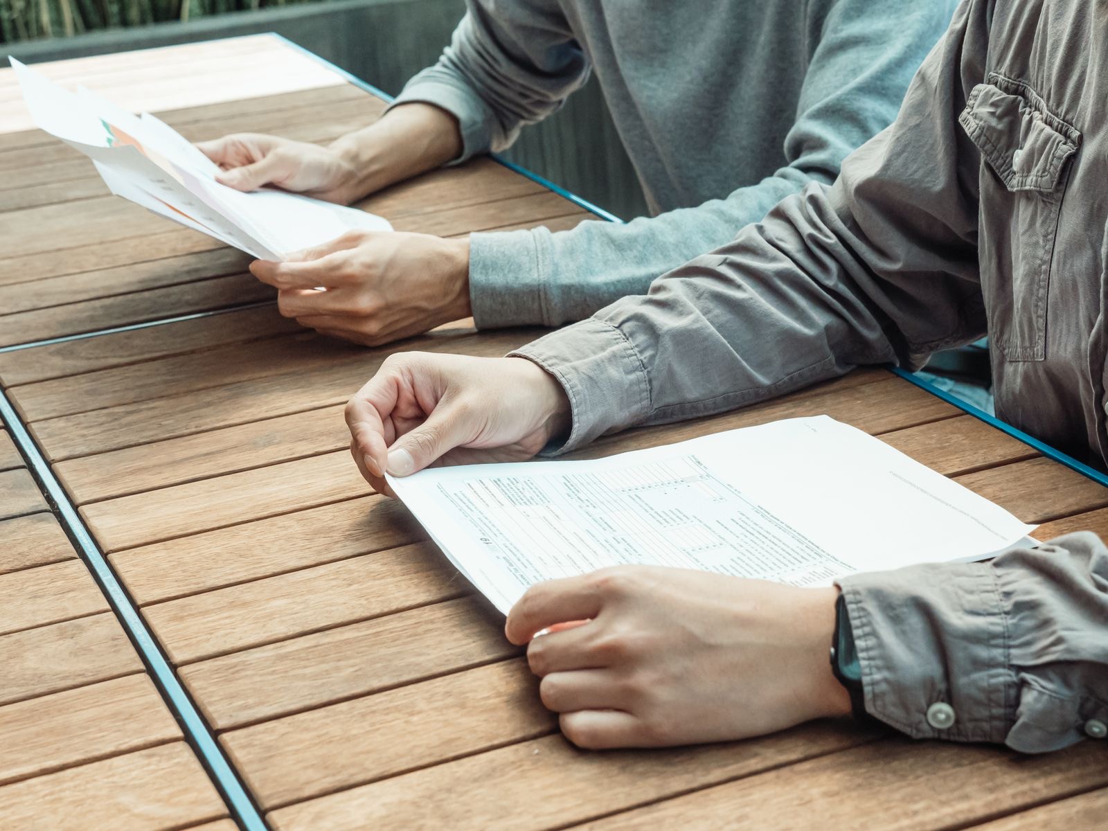 Two people reviewing printed annual accounts at a meeting table