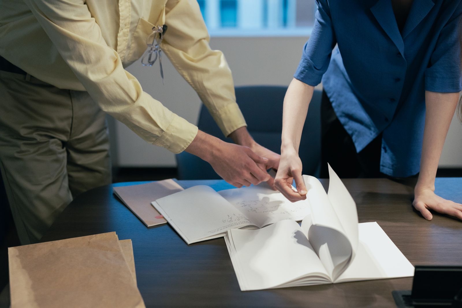 Two people at a table reviewing a printed business plan with charts.
