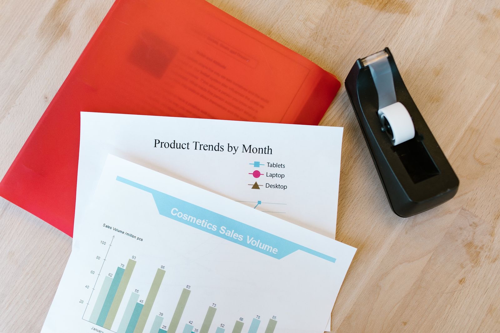 Printed group chart beside a ring binder and a laptop on a desk