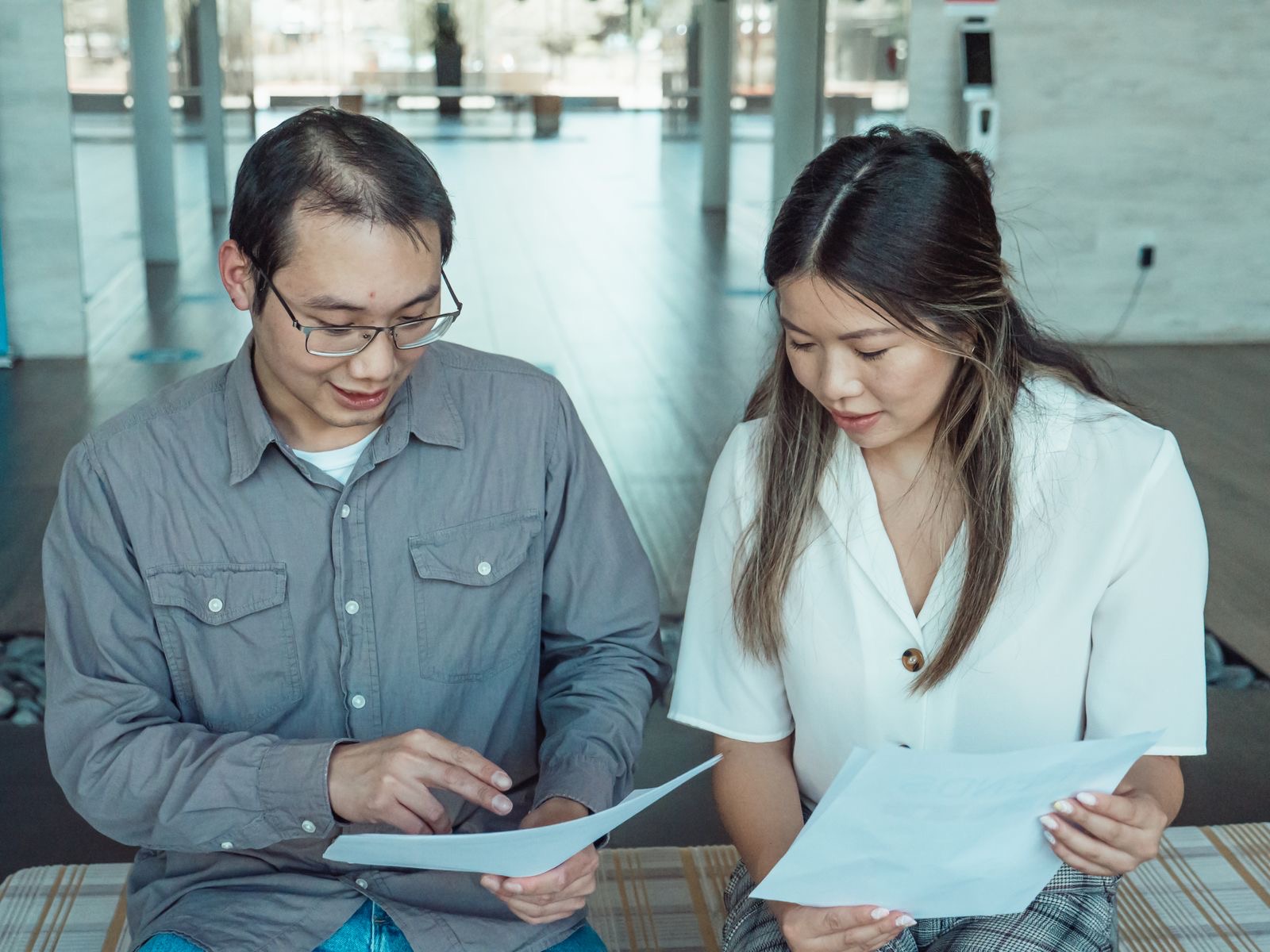 Two colleagues reviewing a schedule on a laptop screen at an office desk