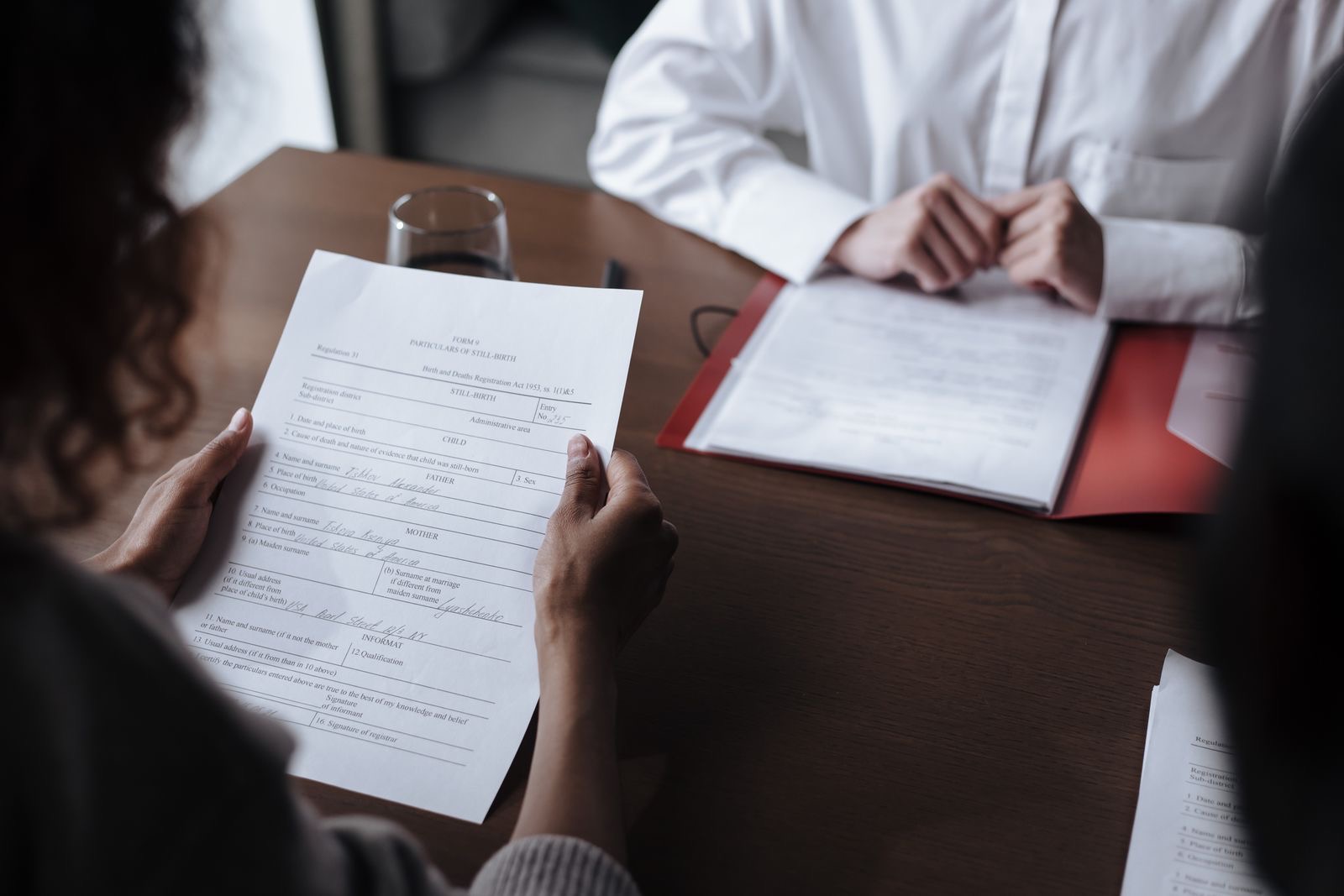 Two people at an office table reading a printed letter from the tax administration